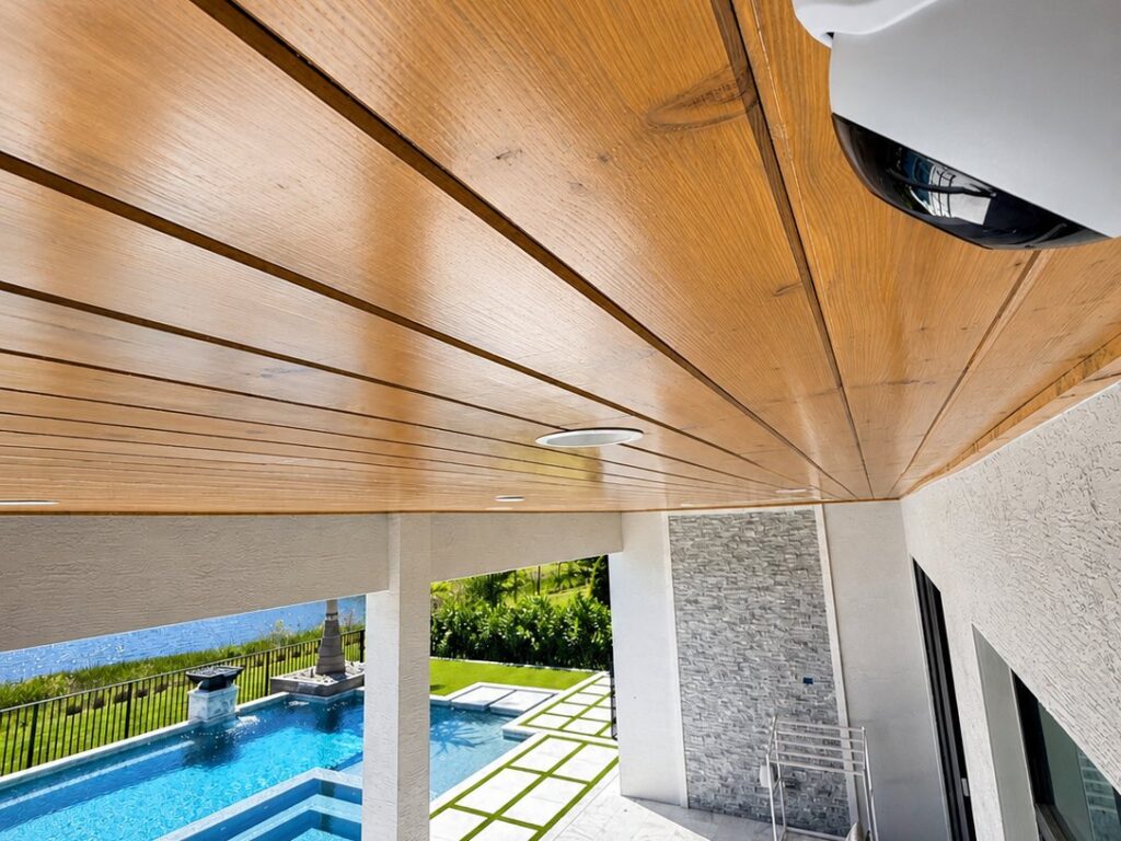 Ubiquiti security camera installed under a modern wood-ceiling patio overlooking a pool in Palm Beach County FL